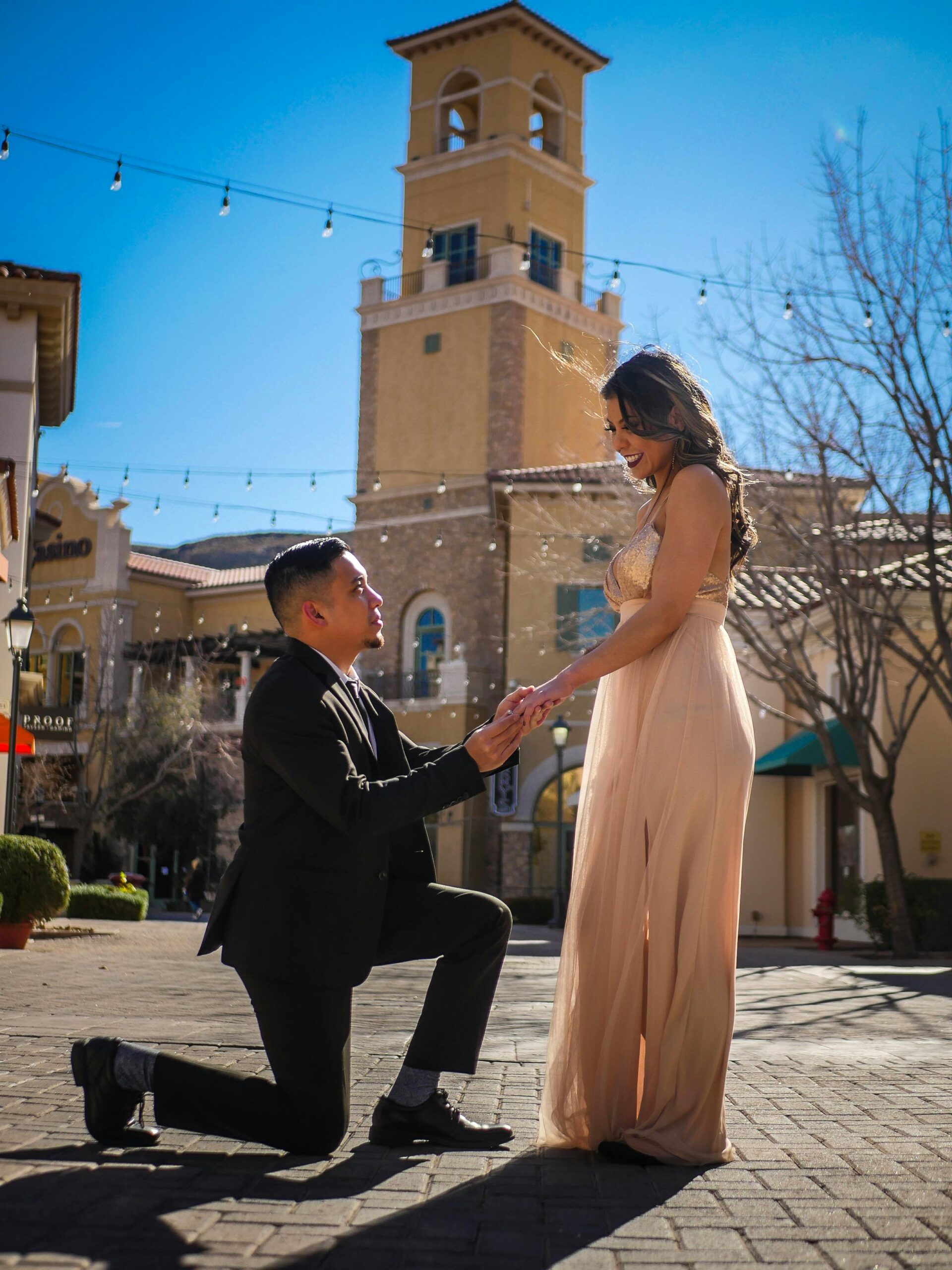 Man proposing to woman on a sunny day, a romantic moment captured outdoors.